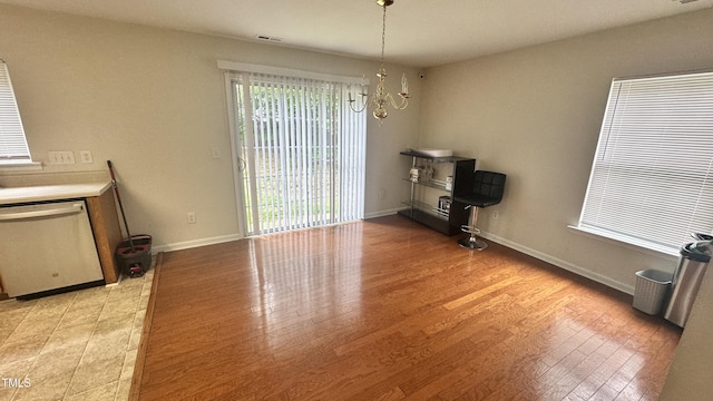 6005 Namozine Ct, Raleigh, NC 27610 - unfurnished dining area with plenty of natural light, a chandelier, light wood finished floors, and baseboards