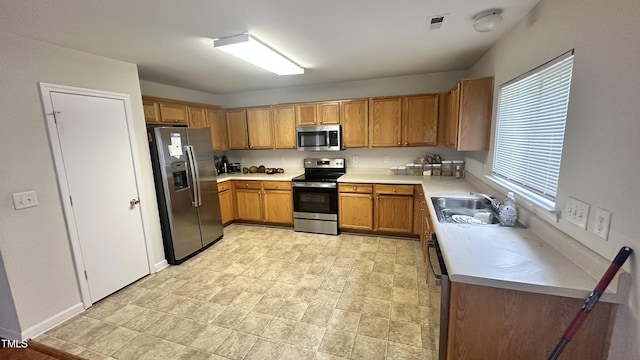 6005 Namozine Ct, Raleigh, NC 27610 - kitchen with appliances with stainless steel finishes, light countertops, brown cabinetry, and a sink