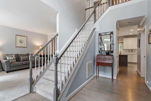 2422 Castleburg Dr, Apex, NC 27523 - stairway featuring wood finished floors, ornamental molding, and a high ceiling