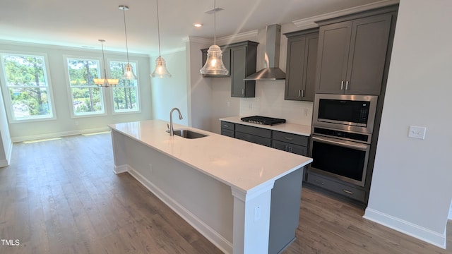 691 Bandon Aly, Cary, NC 27513 - kitchen featuring stainless steel appliances, a sink, wall chimney exhaust hood, backsplash, and baseboards