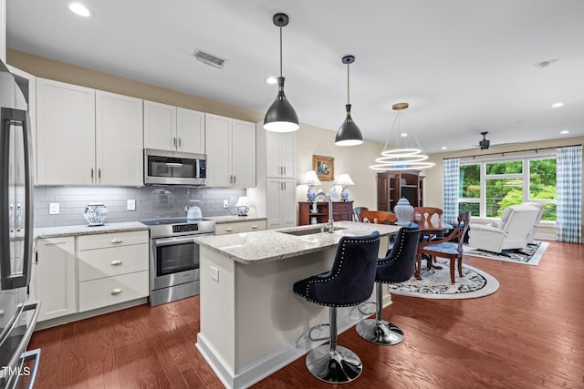 515 N Churton St Unit 203, Hillsborough, NC 27278 - kitchen with stainless steel appliances, a sink, a kitchen bar, dark wood-style flooring, and white cabinets