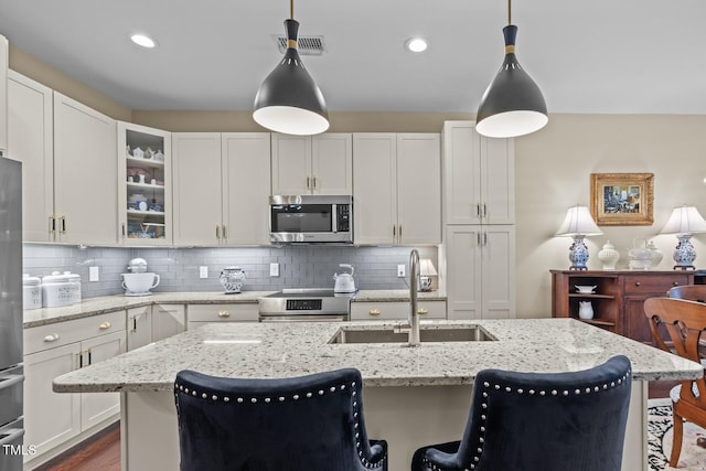 515 N Churton St Unit 203, Hillsborough, NC 27278 - kitchen with stainless steel appliances, a sink, a kitchen bar, glass insert cabinets, and white cabinetry