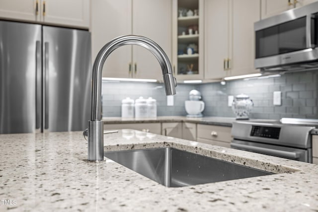 515 N Churton St Unit 203, Hillsborough, NC 27278 - kitchen with appliances with stainless steel finishes, tasteful backsplash, glass insert cabinets, and light stone countertops