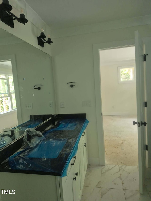 701 Locust Ln, Raleigh, NC 27603 - bathroom featuring vanity, marble look tiles, and healthy amount of natural light