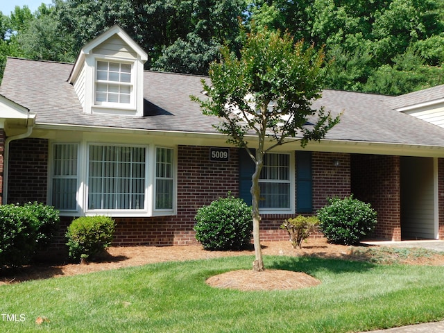 5009 Tower Rd Unit B, Greensboro, NC 27410 - cape cod-style house featuring brick siding, a front lawn, and a shingled roof