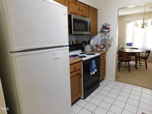 5009 Tower Rd Unit B, Greensboro, NC 27410 - kitchen with freestanding refrigerator, stainless steel microwave, electric stove, light colored carpet, and brown cabinetry