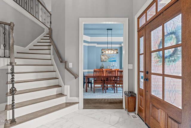 204 Franconia Way, Apex, NC 27502 - entryway with stairs, a chandelier, marble look tiles, and healthy amount of natural light