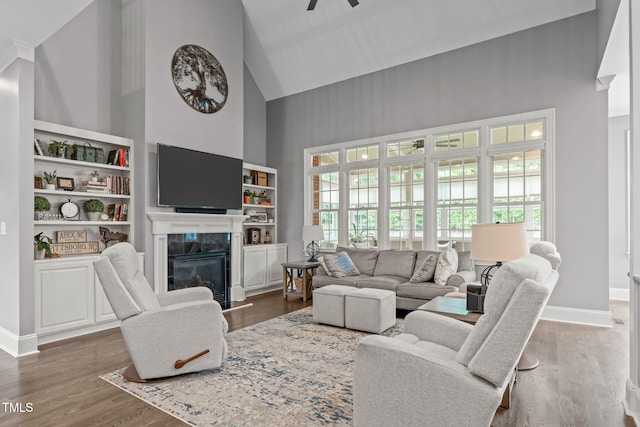 204 Franconia Way, Apex, NC 27502 - living area featuring high vaulted ceiling, a premium fireplace, a ceiling fan, wood finished floors, and built in shelves