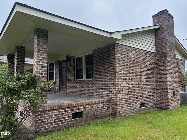11477 NC-87, Elizabethtown, NC 28337 - view of side of property featuring crawl space, a chimney, brick siding, and a lawn