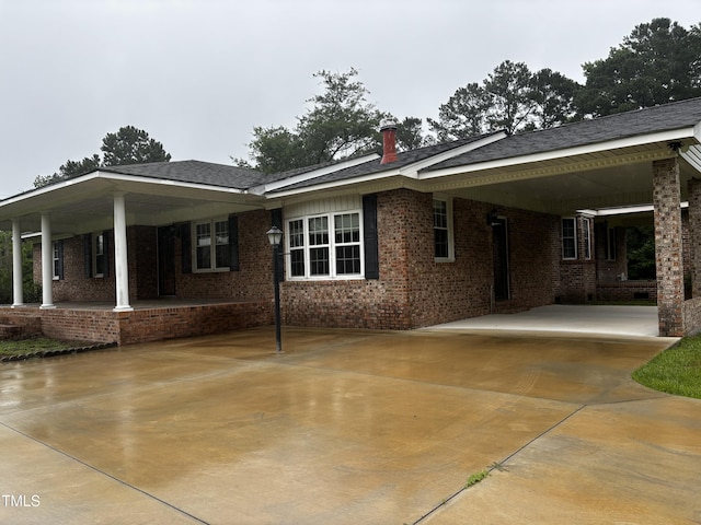 11477 NC-87, Elizabethtown, NC 28337 - view of property exterior with brick siding, an attached carport, concrete driveway, and covered porch