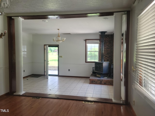 11477 NC-87, Elizabethtown, NC 28337 - entryway with a wood stove, healthy amount of natural light, wood finished floors, a chandelier, and a textured ceiling