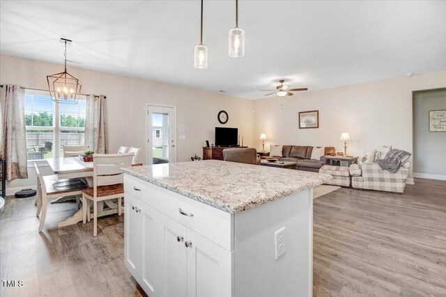 607 Laurel Lake Rd, Salemburg, NC 28385 - kitchen featuring a chandelier, light wood-style flooring, ceiling fan, a kitchen island, and hanging light fixtures