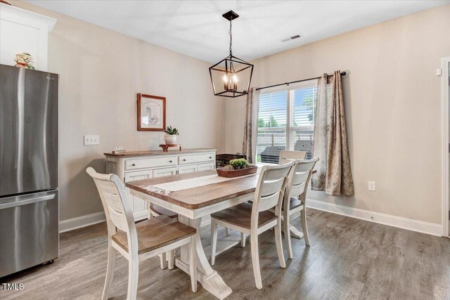 607 Laurel Lake Rd, Salemburg, NC 28385 - dining room with light wood-style flooring, a chandelier, and baseboards