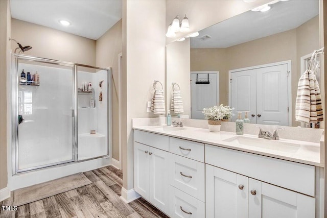 607 Laurel Lake Rd, Salemburg, NC 28385 - full bathroom with a stall shower, double vanity, wood finished floors, and baseboards