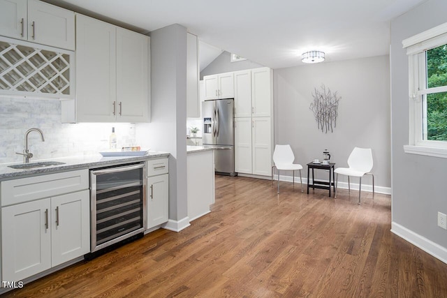 123 Becket Bnd, Pittsboro, NC 27312 - kitchen featuring stainless steel fridge, a sink, beverage cooler, backsplash, and white cabinetry