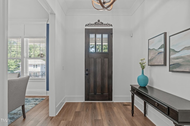415 1st St, Apex, NC 27502 - entryway with wood finished floors, a chandelier, ornamental molding, and baseboards