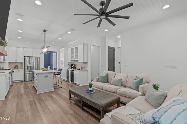 415 1st St, Apex, NC 27502 - living area featuring beverage cooler, ceiling fan, crown molding, recessed lighting, and light wood-style floors