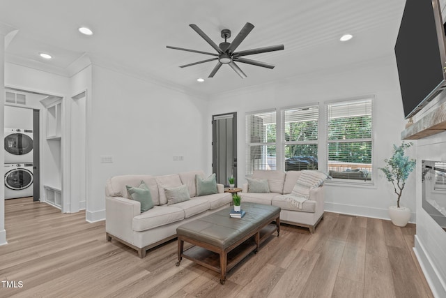 415 1st St, Apex, NC 27502 - living area with estacked washer and dryer, ornamental molding, light wood-style floors, a ceiling fan, and recessed lighting