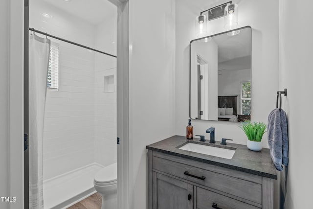 415 1st St, Apex, NC 27502 - bathroom with vanity, connected bathroom, a tile shower, and toilet