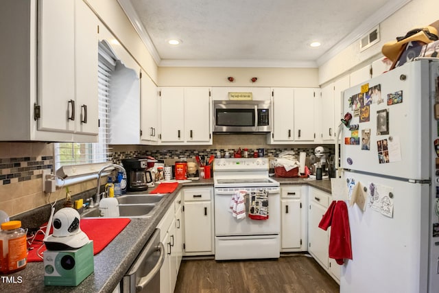 6424 Bretton Woods Dr, Hope Mills, NC 28348 - kitchen featuring stainless steel appliances, a sink, dark wood-type flooring, white cabinetry, and crown molding