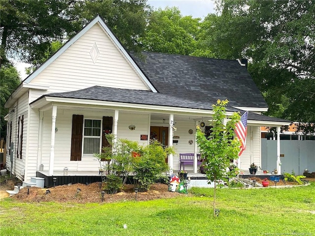 135 S Patterson S, Maxton, NC 28364 - view of front facade with covered porch, a front lawn, and a shingled roof