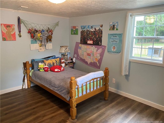135 S Patterson S, Maxton, NC 28364 - bedroom featuring a textured ceiling, wood finished floors, and baseboards