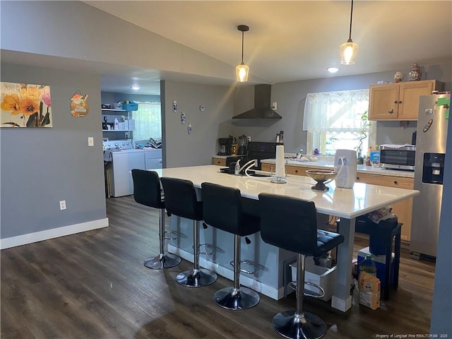 135 S Patterson S, Maxton, NC 28364 - kitchen with separate washer and dryer, wall chimney range hood, stainless steel appliances, light brown cabinetry, and vaulted ceiling