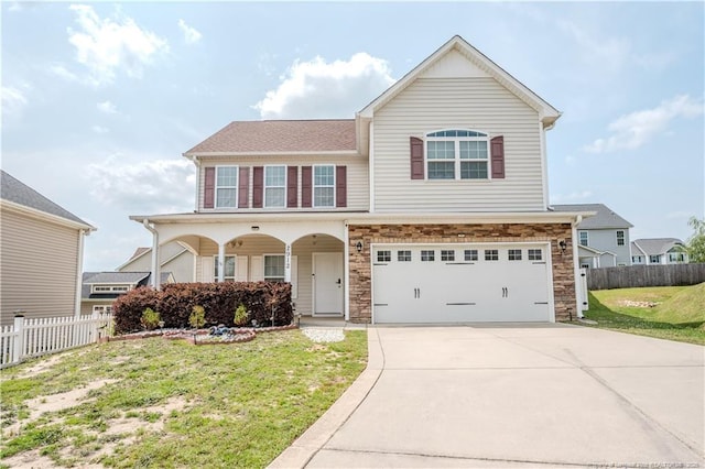 2912 Seafarer Dr, Fayetteville, NC 28306 - view of front of property featuring a garage, concrete driveway, stone siding, and covered porch