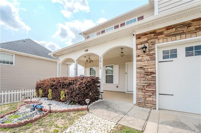 2912 Seafarer Dr, Fayetteville, NC 28306 - doorway to property featuring stone siding, covered porch, and a garage