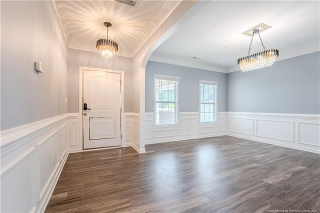 2912 Seafarer Dr, Fayetteville, NC 28306 - foyer with a chandelier, arched walkways, a decorative wall, a wainscoted wall, and dark wood-type flooring