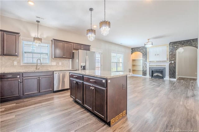 2912 Seafarer Dr, Fayetteville, NC 28306 - kitchen featuring stainless steel appliances, a sink, arched walkways, and dark brown cabinetry