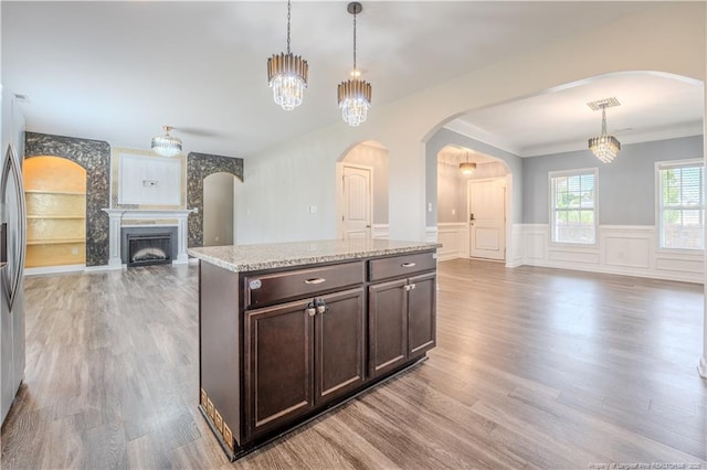 2912 Seafarer Dr, Fayetteville, NC 28306 - kitchen featuring open floor plan, dark brown cabinetry, light wood-type flooring, wainscoting, and decorative light fixtures