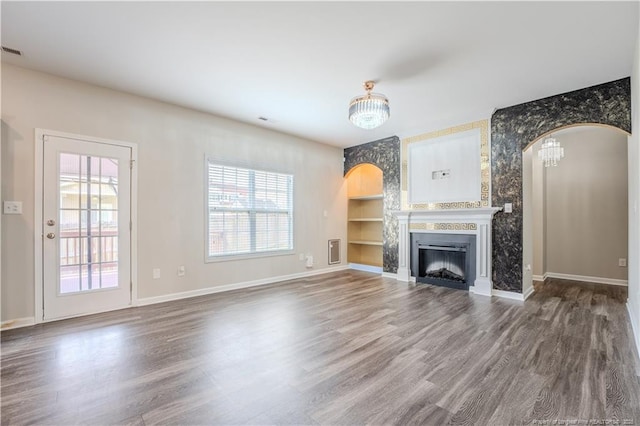 2912 Seafarer Dr, Fayetteville, NC 28306 - unfurnished living room featuring arched walkways, healthy amount of natural light, and wood finished floors