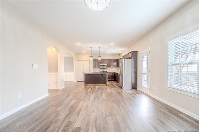 2912 Seafarer Dr, Fayetteville, NC 28306 - unfurnished living room with arched walkways, light wood-style floors, plenty of natural light, a chandelier, and recessed lighting