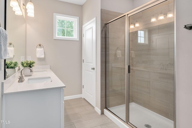 31 Pascoli Ct, Clayton, NC 27527 - bathroom featuring double vanity, a shower stall, baseboards, and a chandelier