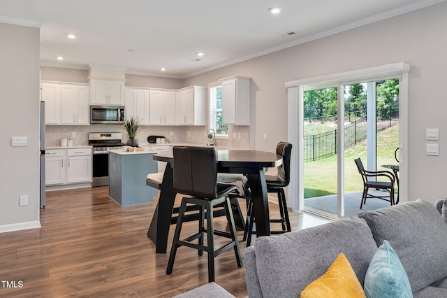 31 Pascoli Ct, Clayton, NC 27527 - kitchen featuring stainless steel appliances, a center island, decorative backsplash, dark wood-style floors, and crown molding
