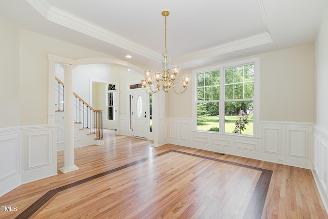 6553 Vintage Ridge Ln, Fuquay Varina, NC 27526 - unfurnished dining area featuring a tray ceiling, crown molding, light wood-style flooring, a decorative wall, and a wainscoted wall
