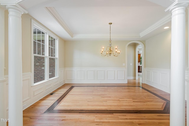 6553 Vintage Ridge Ln, Fuquay Varina, NC 27526 - unfurnished dining area featuring arched walkways, a chandelier, a tray ceiling, a wainscoted wall, and light wood finished floors