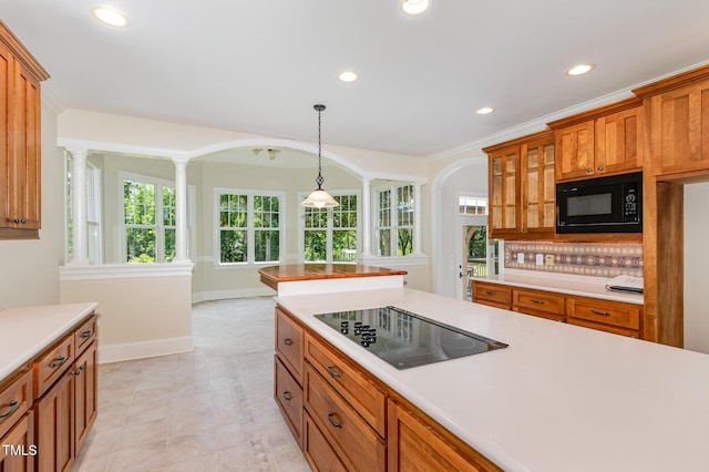 6553 Vintage Ridge Ln, Fuquay Varina, NC 27526 - kitchen featuring black appliances, ornate columns, arched walkways, brown cabinetry, and light countertops