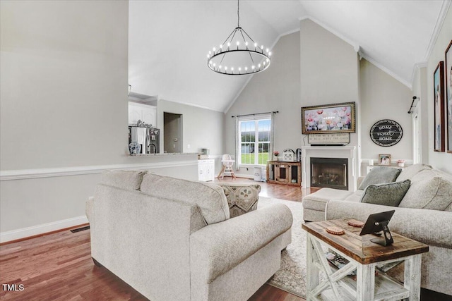 103 Kayla Marie Ln, Goldsboro, NC 27530 - living area with high vaulted ceiling, a chandelier, dark wood-style floors, a fireplace, and baseboards