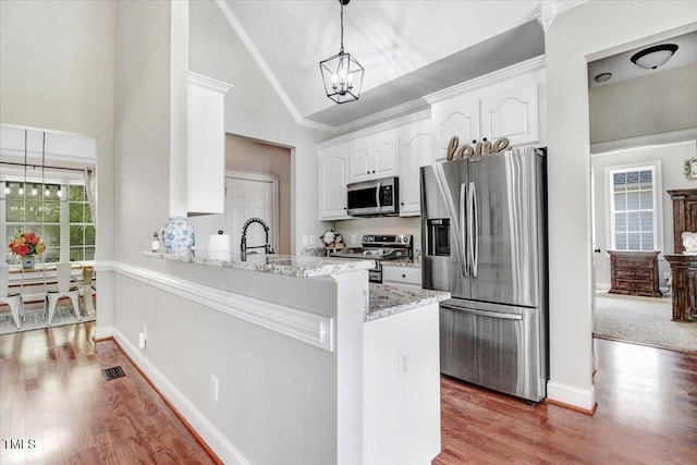 103 Kayla Marie Ln, Goldsboro, NC 27530 - kitchen featuring stainless steel appliances, high vaulted ceiling, a chandelier, white cabinets, and light wood-style flooring