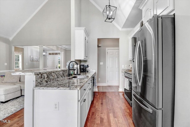 103 Kayla Marie Ln, Goldsboro, NC 27530 - kitchen featuring appliances with stainless steel finishes, a sink, high vaulted ceiling, white cabinetry, and a peninsula