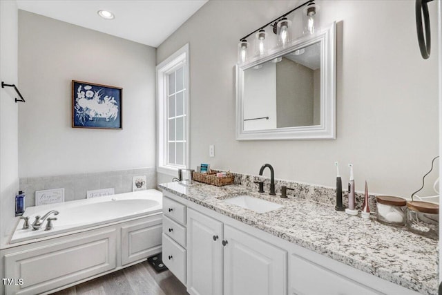 103 Kayla Marie Ln, Goldsboro, NC 27530 - full bathroom featuring vanity, a garden tub, wood finished floors, and recessed lighting