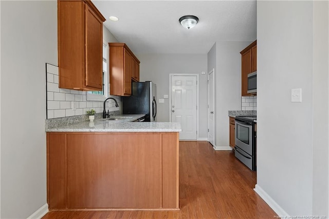 4420 Battle Forest Rd, Hope Mills, NC 28348 - kitchen featuring appliances with stainless steel finishes, a sink, tasteful backsplash, dark wood-style floors, and baseboards