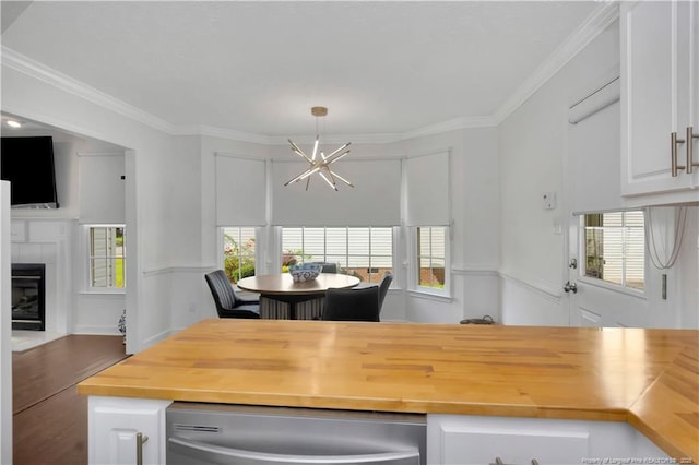 1502 E 11th St, Lumberton, NC 28358 - dining room featuring a chandelier, healthy amount of natural light, a fireplace, crown molding, and wood finished floors
