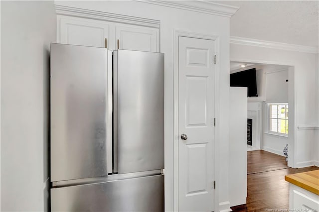 1502 E 11th St, Lumberton, NC 28358 - kitchen featuring freestanding refrigerator, crown molding, white cabinets, dark wood-style floors, and baseboards