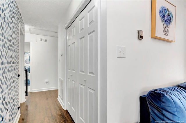 1502 E 11th St, Lumberton, NC 28358 - hallway with dark wood-style flooring, a textured ceiling, baseboards, and wallpapered walls