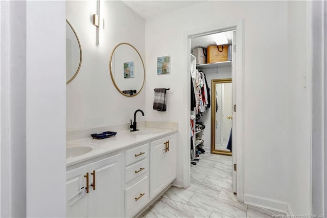 1502 E 11th St, Lumberton, NC 28358 - full bathroom with marble finish flooring, double vanity, a spacious closet, and baseboards