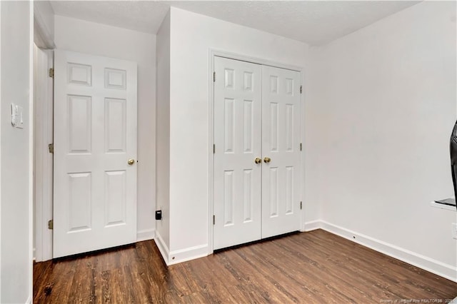 1502 E 11th St, Lumberton, NC 28358 - unfurnished bedroom featuring wood finished floors, a closet, and baseboards
