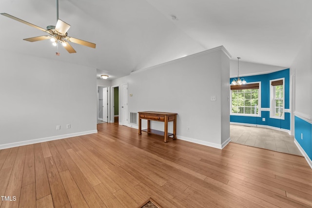 1383 Deercroft Ct, Graham, NC 27253 - empty room with vaulted ceiling, light wood-style floors, ceiling fan, a chandelier, and baseboards